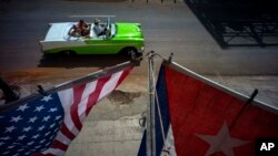 Bendera nasional AS dan Kuba berkibar dari sebuah balkon di kota tua Havana.