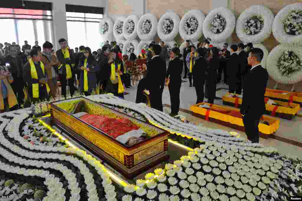 A man lying in a coffin amidst flowers takes part in a funeral simulation during an event organized by the local government promoting the upcoming Qingming, or Tomb Sweeping Day, at a funeral parlor in Jinhua, Zhejiang province, China, March 27, 2019.