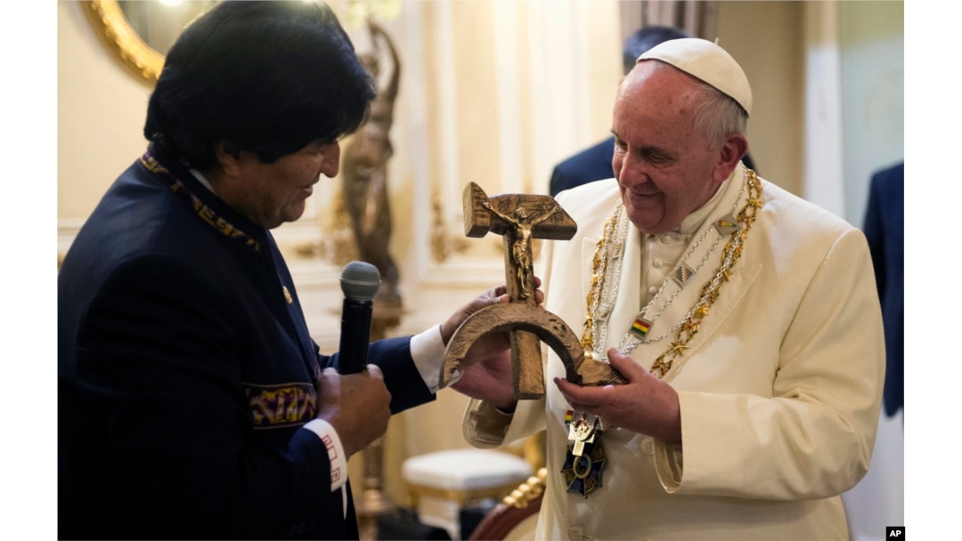 Pope Francis is presented with a gift of a crucifix carved into a wooden hammer and sickle, the Communist symbol uniting labor and peasants, by Bolivian President Evo Morales in La Paz, Bolivia, Wednesday, July 8, 2015.