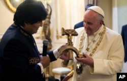 Pope Francis is presented with a gift of a crucifix carved into a wooden hammer and sickle, the Communist symbol uniting labor and peasants, by Bolivian President Evo Morales in La Paz, Bolivia, Wednesday, July 8, 2015.