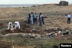 Trabajadores forenses levantan el cuerpo de una persona que murió en un naufragio de venezolanos que huían a Curazao. Willemstad, enero 12, 2018.