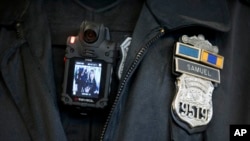 Policajac pokazuje kameru koja se koristi kao deo pilot projekta u Filadelfiji. Fotografisano 11. decembra, 2014. (Foto: AP/Matt Rourke)