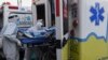 Tenaga kesehatan membawa pasien Covid-19 ke rumah sakit umum Medellin, Kolombia, dengan ambulans, 3 Agustus 2020. (Foto: JOAQUIN SARMIENTO / AFP)