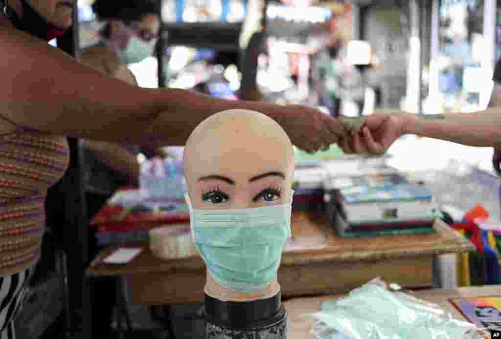 Un vendedor ambulante utiliza una cabeza de maniquí para mostrar una máscara protectora en el centro de Santiago, Chile, el martes 17 de marzo de 2020.