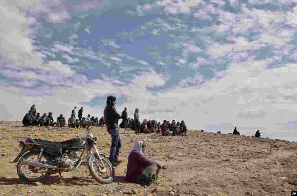People watch the fighting in Kobani, Syria from a hilltop on the outskirts of Suruc, Turkey, Oct. 23, 2014.
