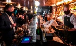 Pelanggan menikmati minuman di bar Nick & Nora setelah pemerintah melonggarkan restriksi Covid-19 di Melbourne, tengah malam, 28 Oktober 2020.
