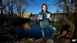 FILE - Sarah Sherbert poses for a photo in Anderson, S.C., on Feb. 5, 2018, holding photos of her children when they were infants. Sherbert, 31, said her drug use began eight years ago after she was prescribed opioid painkillers for injuries from a car ac