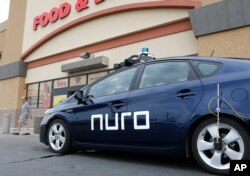 FILE - In this Aug. 16, 2018, photo a self-driving Nuro vehicle parks outside a Fry's supermarket, which is owned by Kroger, as part of a pilot program for grocery deliveries in Scottsdale, Ariz.
