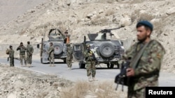 Des soldats de l'Armée nationale afghane (ANA) surveillent les environs à un poste de contrôle dans la province de Logar, en Afghanistan, le 16 février 2016.