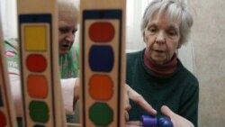 A patient with dementia, right, works on a puzzle with caregivers at the Morning Glory Retirement Home in State Line, Pennsylvania