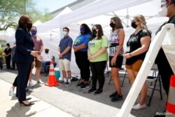 La vicepresidenta de EE. UU., Kamala Harris, a la izquierda, habla con trabajadores en una clínica emergente de vacunación COVID-19 afuera del Centro Internacional de Capacitación Carpenters en Las Vegas, Nevada, el 3 de julio de 2021.
