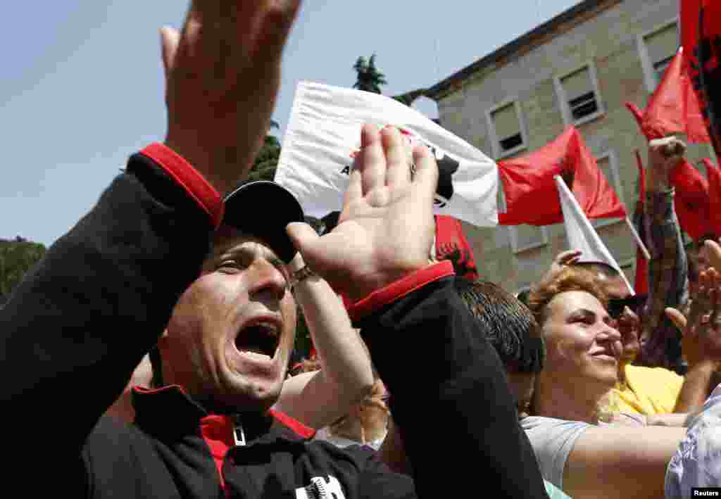 Pendukung Partai Albania Merah dan Aliansi Hitam meneriakkan slogan-slogan dalam demonstrasi Hari Buruh di depan kantor perdana menteri Albania di Tirana (1/5).