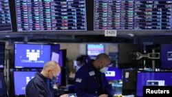 FILE - Traders work on the trading floor at the New York Stock Exchange (NYSE) in Manhattan, New York City, Dec. 28, 2021. 