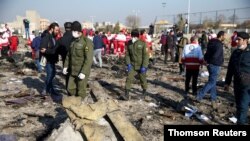 تصویری از ماموران امنیتی و کارمندان صلیب سرخ در محل سقوط هواپیمای اوکراینی پرواز پی‌اس‌٧۵۲