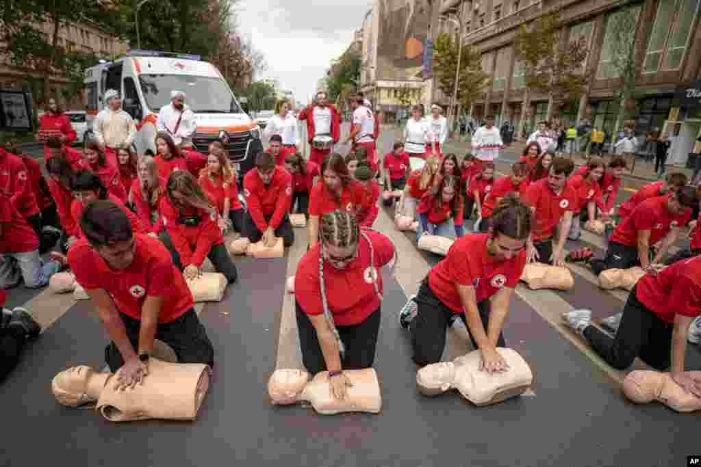 Romanian Red Cross volunteers perform resuscitation on mannequins during a flash mob to mark the World Restart a Heart Day in Bucharest.