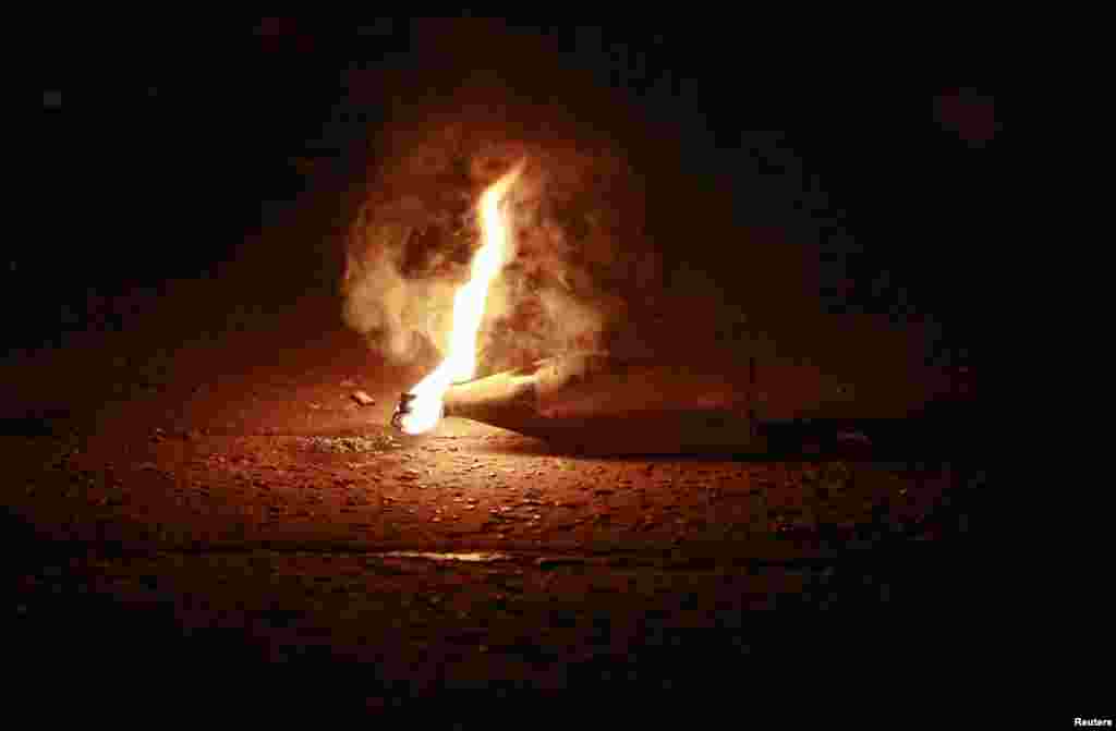 An unexploded petrol bomb flares in the Woodvale Road area of North Belfast, Northern Ireland during the third night of unrest after an Orange Parade was blocked from marching past the Nationalist Ardoyne area in Belfast.