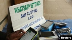 Un vendeur de rue ajuste les paramètres internet d'un client sur son téléphone à Harare, au Zimbabwe, le 13 janvier 2017.