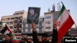 Un hombre iraní empuña un retrato del general Qassem Soleimani, mientras celebran el ataque con misiles iraníes a bases estadounidenses en Iraq, que no dejaron víctimas estadounidenses. Cortesía.