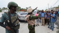 Seorang polisi Kenya tampak mengambil foto warga Haiti di di Port-au-Prince, pada 3 Juli 2024. (Foto: AP/Odelyn Joseph)