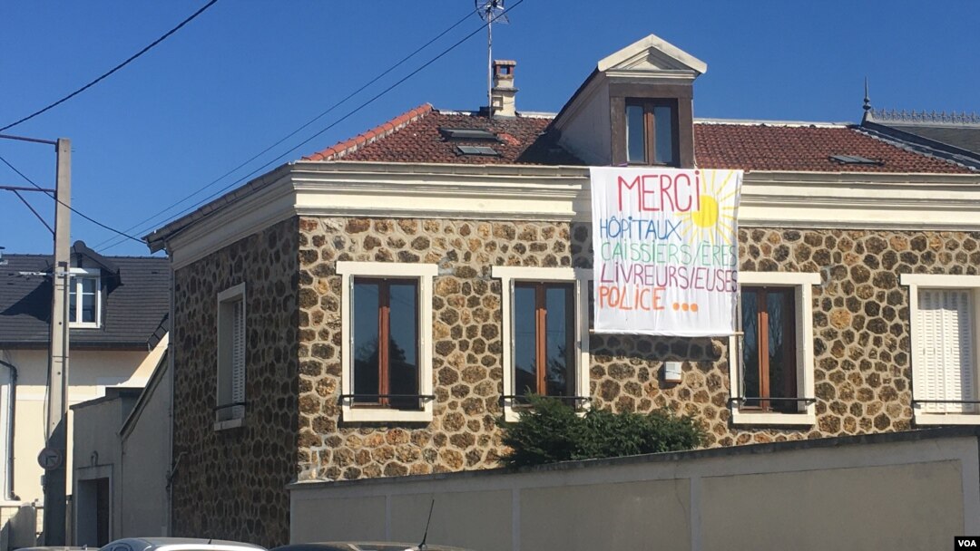 A banner outside Paris thanking health care workers and others on the frontlines of the coronavirus battle. (Lisa Bryant/VOA)