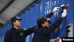 Chinese customs officers check for signs of radiation at the Yangshan Port in Shanghai December 7, 2011. The United States and China launched a radiation detection system at the Shanghai port.