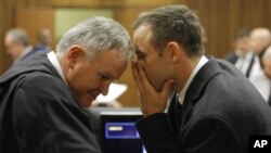 Oscar Pistorius talks with attorney Barry Roux, left, on the second day of trial, Pretoria, March 4, 2014.