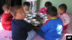 In this photo provided by the United Nation's World Food Program, a North Korean eat their lunch at a government run nursery in Pyongyang October 18, 2005. 