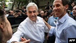 FILE - Chilean former President Sebastian Pinera (L) and Chilean right-wing lawyer and Santiago's mayoral candidate Felipe Alessandri greet supporters during Municipal elections in Santiago, Oct. 23, 2016.