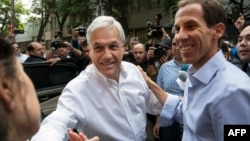 FILE - Chilean former President Sebastian Pinera (L) and Chilean right-wing lawyer and Santiago's mayoral candidate Felipe Alessandri greet supporters during Municipal elections in Santiago, Oct. 23, 2016.