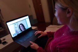 FILE - A patient sits in the living room of her apartment in the Brooklyn borough of New York, Jan. 14, 2019, during a telemedicine video conference with her doctor.