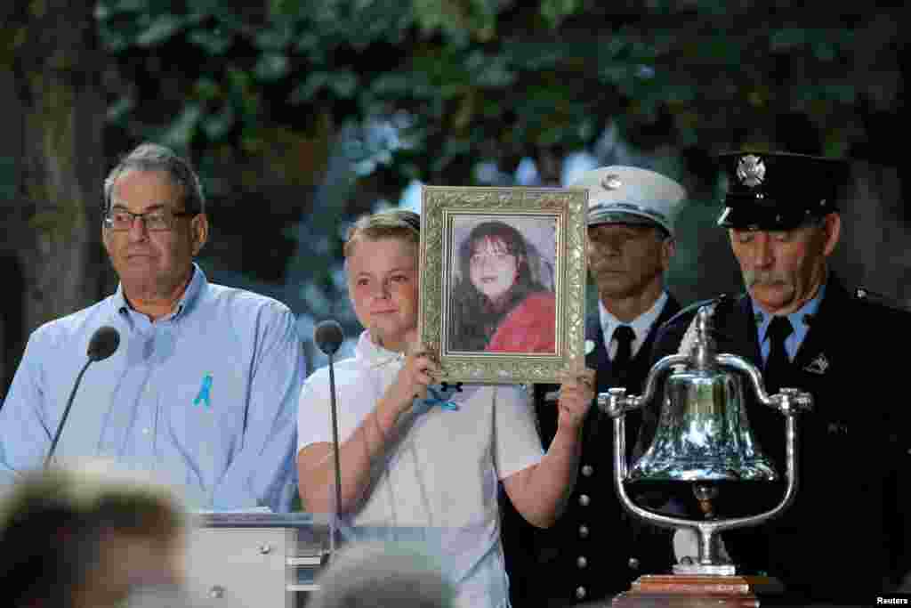 A boy holds up a photo of a 9/11 victim during the reading of victims&#39; names during ceremonies at the 911 Memorial in lower Manhattan, New York, Sept. 11, 2019.
