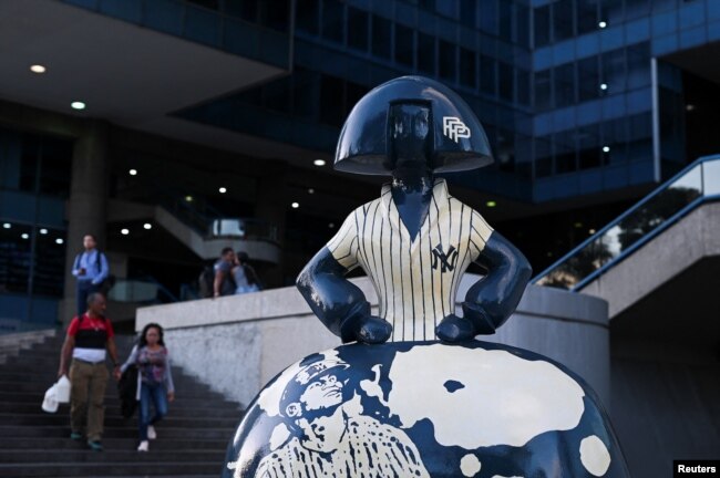 People walk near a sculpture by Venezuelan artist Antonio Azzato as part of the “Meninas Caracas Gallery” street exhibit which plays homage to Spanish artist Diego Velazquez's “Las Meninas” in Caracas, Venezuela January 10, 2024. (REUTERS/Gaby Oraa)