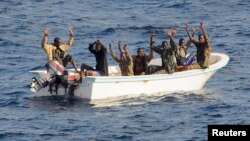 Suspected pirates keep their hands in the air as directed by sailors aboard the guided-missile cruiser USS Vella Gulf (CG 72) (not shown), in the Gulf of Aden, February 11, 2009.