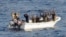 Suspected pirates keep their hands in the air as directed by sailors aboard the guided-missile cruiser USS Vella Gulf (CG 72) (not shown), in the Gulf of Aden, February 11, 2009.