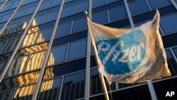 Bendera Pfizer dipasang di depan kantor pusat global di New York (23/11). (AP/Mark Lennihan)