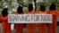 Protesters depicting detainees of the US detention facility at Guantanamo Bay, Cuba, hold a banner, during a demonstration outside the US embassy in central London, May 18, 2013.