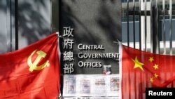 Banderas de del Partido Comunista Chino ondean fuera del edificio del gobierno central en Hong Kong.