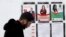 A man walks past campaign posters on Dec. 23, 2023, in Tunis. Tunisians will head to the polls on Sunday for the country's first local elections since voters approved a new constitution last year.