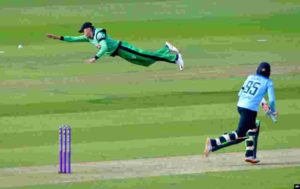 Ireland&#39;s Harry Tector, left, dives to make a catch but misses during the third One Day International cricket match between England and Ireland, at the Ageas Bowl in Southampton, England.