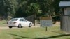 FILE - A car leaves the federal prison in Oakdale, La., Sept. 26, 2006. The federal Bureau of Prisons is locking up all its almost 150,000 inmates in their cells in an unparalleled effort to slow the spread of the coronavirus.