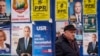 A man walks between panels displaying electoral posters ahead of the Nov. 24 presidential elections in Bucharest, Romania, Nov. 22, 2024. 