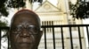 FILE - Cameroon's Christian Tumi poses in front of his diocese in Douala, Oct. 7, 2004.