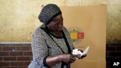 FILE - A woman scrutinizes ballot papers before casting her vote at a polling station in Harare, Zimbabwe, Wednesday, Aug. 23, 2023.