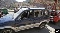 A damaged vehicle purported to belong to an American teacher shot by gunmen is towed away in Taiz, Yemen, Sunday, March 18, 2012.