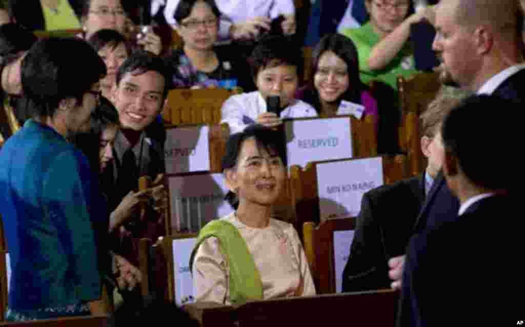 Myanmar opposition leader Aung San Suu Kyi, center, speaks with well-wishers as she waits for the arrival of U.S. President Barack Obama to deliver a speech at University of Yangon's convocation hall in Yangon, Myanmar, Monday, Nov. 19, 2012. (AP Photo/Ge