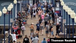 Pocas personas usan máscaras mientras caminan por el muelle de la playa en Oceanside, California, EE. UU., 22 de junio de 2020.