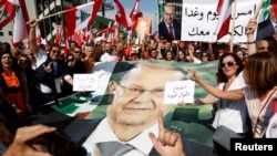 Supporters of Lebanon's President Michel Aoun hold his poster during a rally in Baabda near Beirut, Lebanon, Nov. 3, 2019. 