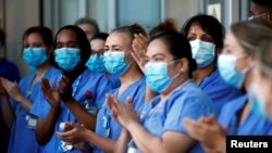 Para petugas kesehatan Inggris (NHS) yang bertugas di Rumah Sakit Royal London Hospital serentak bertepuk tangan saat hari terakhir dari kampanye "Clap for our Carers" untuk mendukung NHS di tengah pandemi COVID-19 pada 28 Mei 2020. (Foto: Reuters/Henry Nicholls)