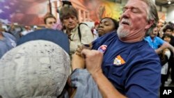 Un simpatizante de Trump lucha con un estudiante hispano que se manifestaba contra las posiciones antiinmigrantes del candidato, durante un mitin en Richmond, Virginia.