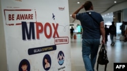 A passenger walks past a banner informing about Monkeypox (MPOX) at Soekarno-Hatta International Airport in Tangerang on August 26, 2024.